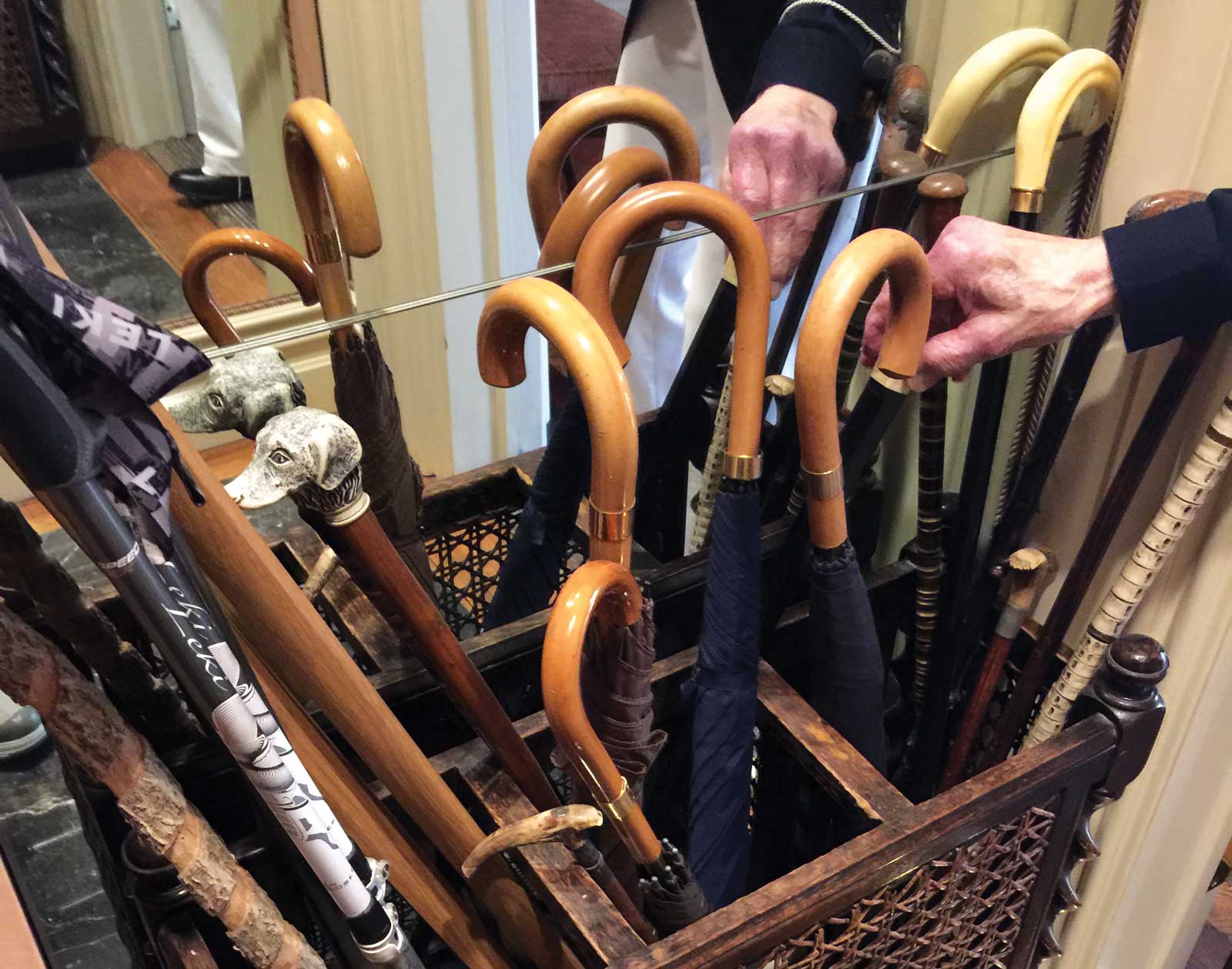 A small collection of canes and walking sticks lay against the wall near the apartment's entrance.